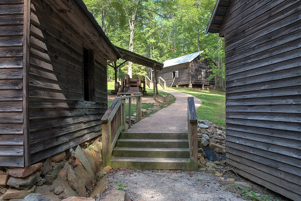 Wooden farm buildings and a footpath at Jarrell Plantation State Historic Site.