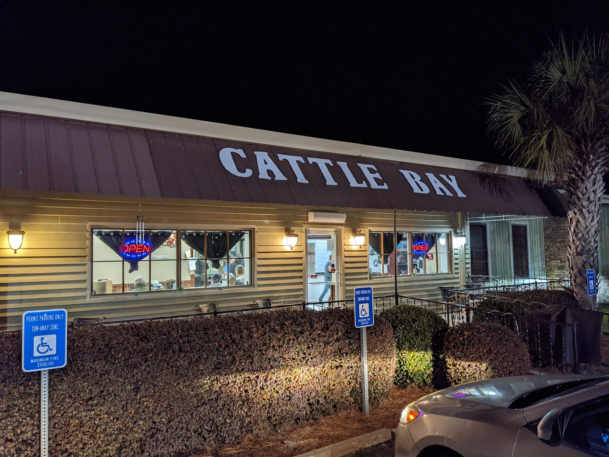 Illuminated Cattle Bay Restaurant exterior in Wrightsville during dinner service.