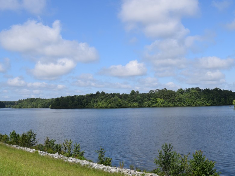 Lake Meriwether and its wooded shoreline under a blue sky.