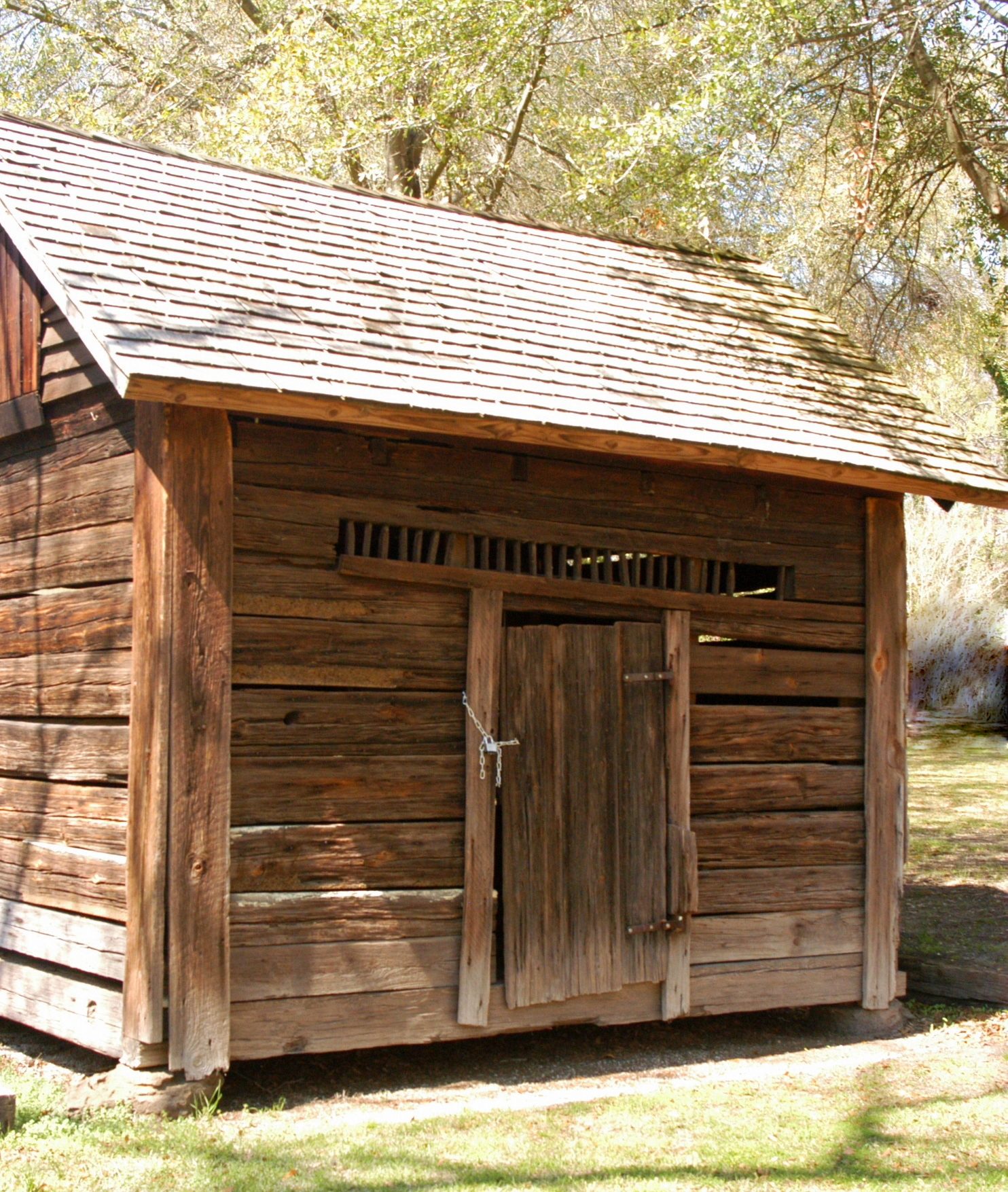 Small historic log jail with a secured wooden door in Warthen.