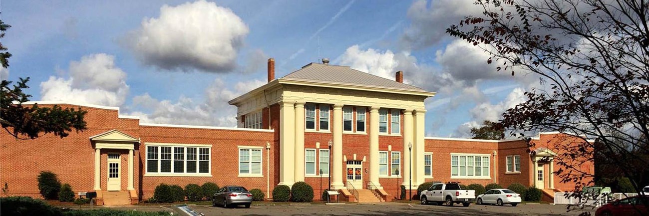 Red-brick Plains High School Visitor Center and Museum with a columned entrance.