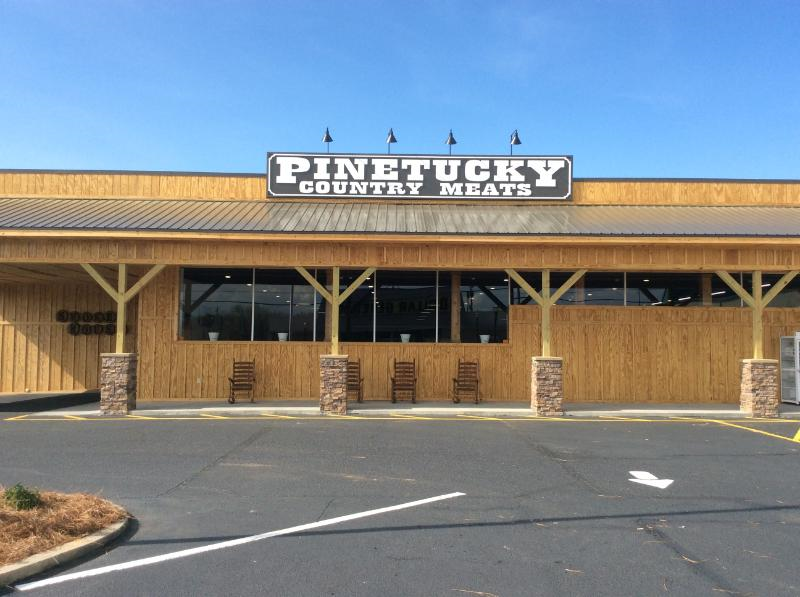 Wood-sided Pinetucky Country Meats storefront with its sign and covered porch in Swainsboro.
