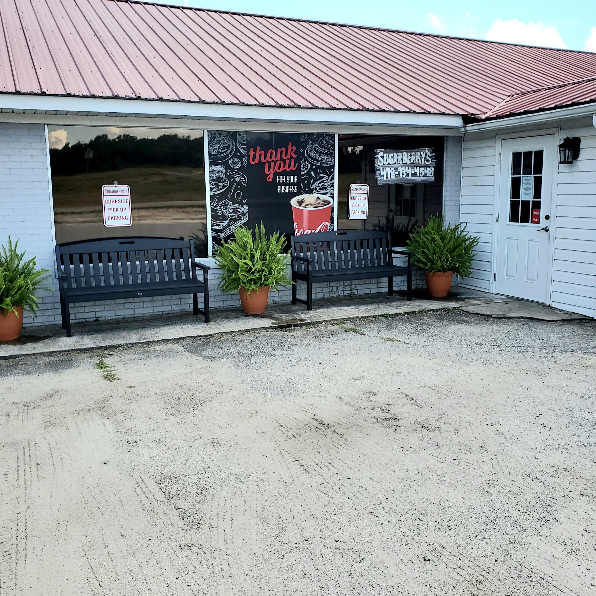 Sugarberry's signed restaurant facade with benches outside in Cochran.