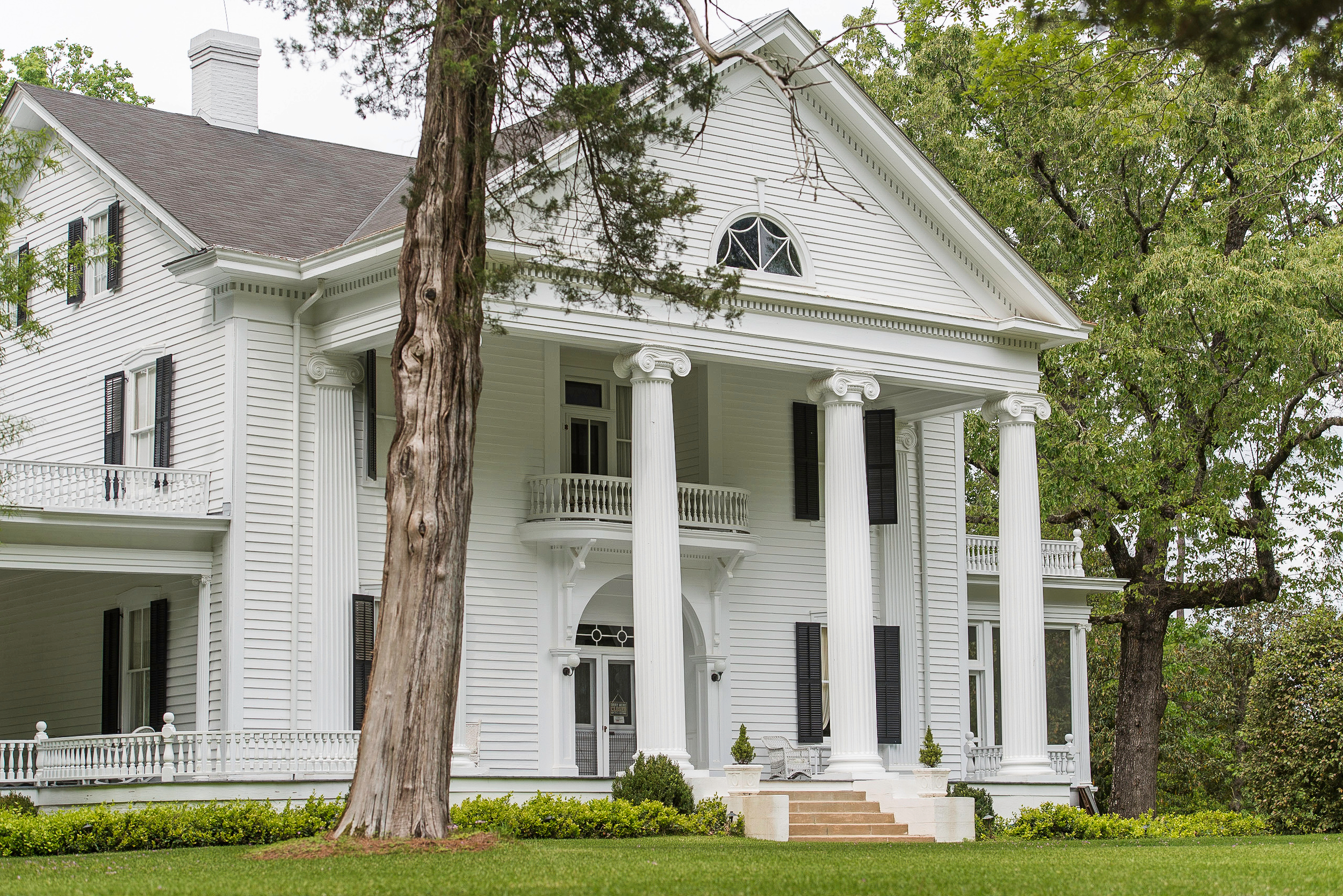 White-columned exterior and landscaped lawn at Hickory Hill in Thomson.