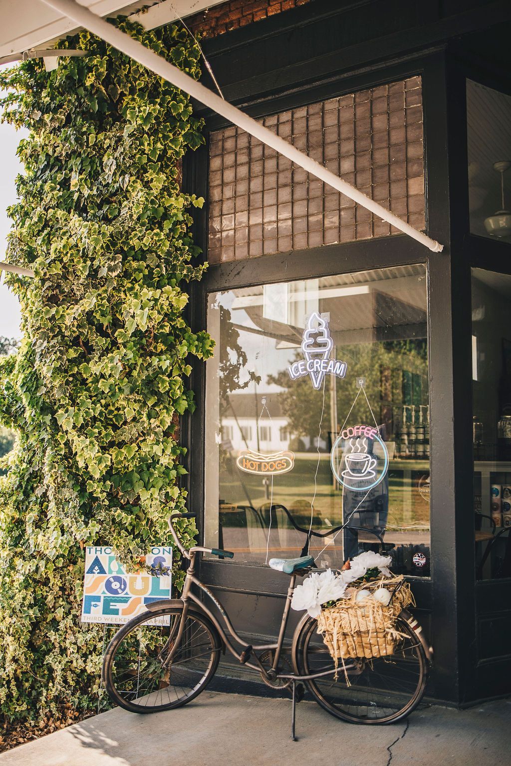 Mercantile entrance with a bicycle display and coffee and ice cream signs.