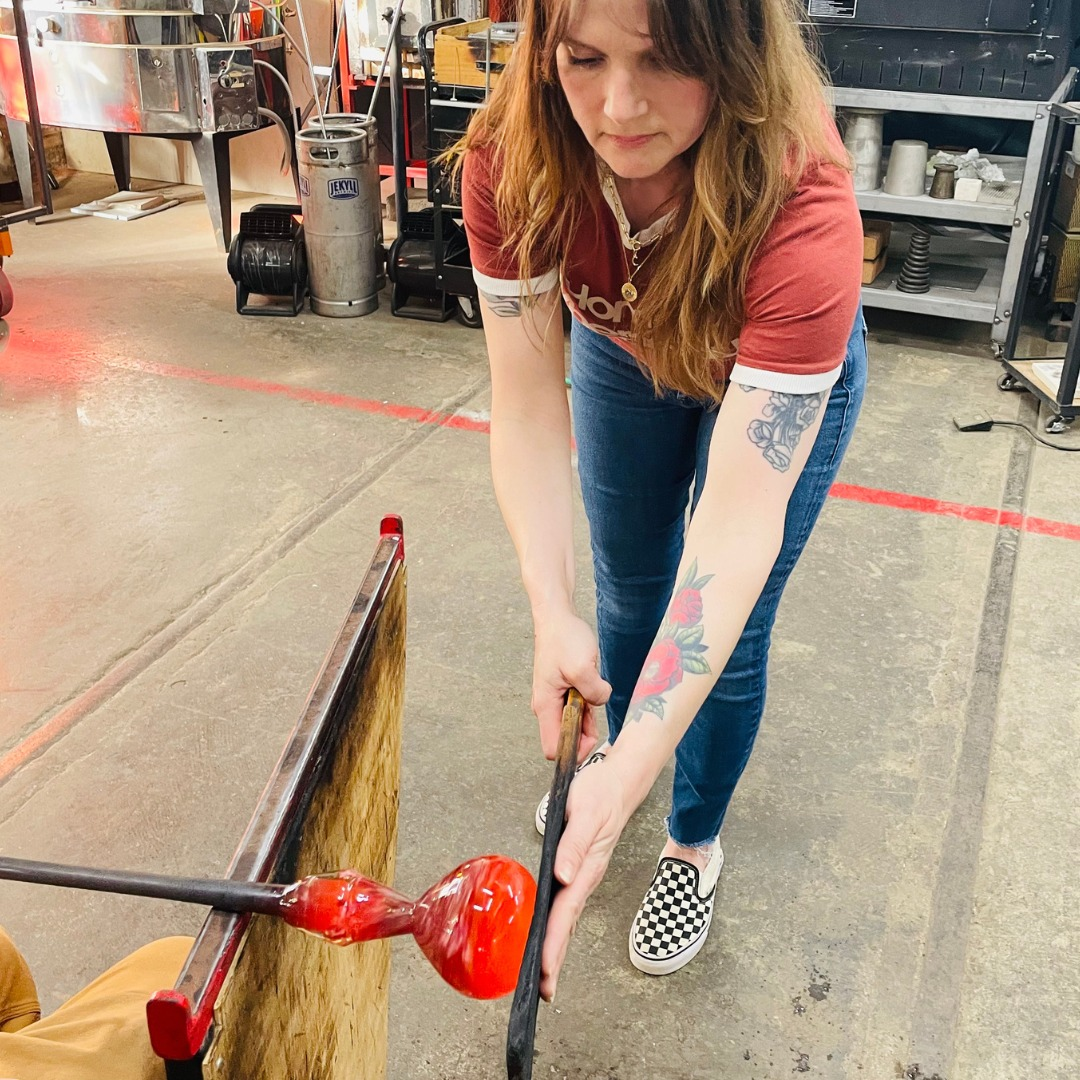 A participant working molten glass inside the stARTup Studios glass workshop.