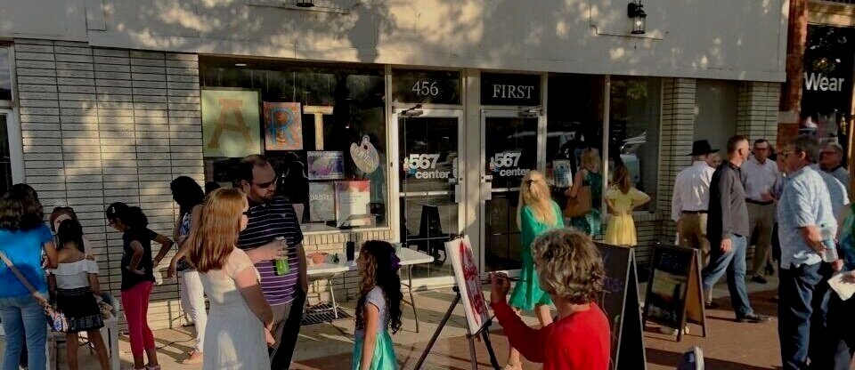 Visitors and a painter outside The 567 Center entrance on First Street.