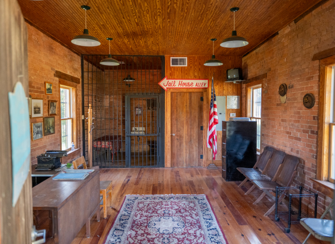 Historic jail cell, benches and local-history displays inside Byron's Old Jail.