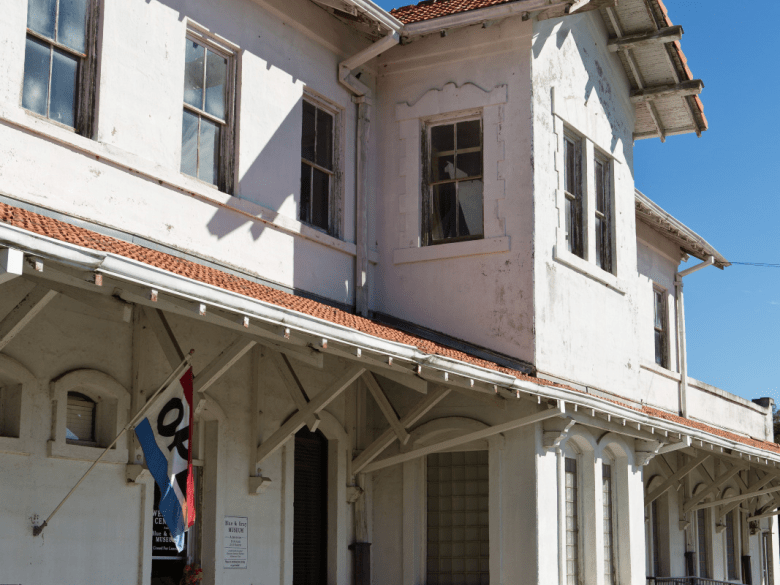 The historic white railroad depot housing Fitzgerald's Blue & Gray Museum, with the museum flag at its entrance.