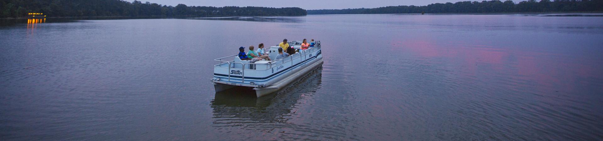 Visitors riding a pontoon boat across Lake Walter F. George at Florence Marina State Park.
