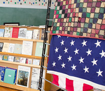 A quilt, historic flag and classroom artifacts inside the Candler County History Museum.