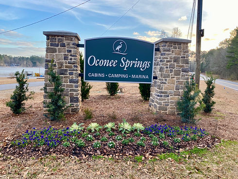 The Oconee Springs entrance monument with the lake and boat ramp behind it.