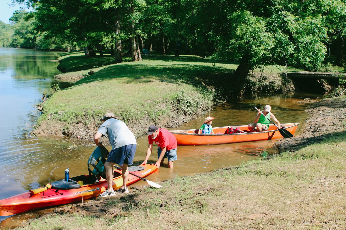 Kayakers and canoeists launching on a wooded Flint River trip.