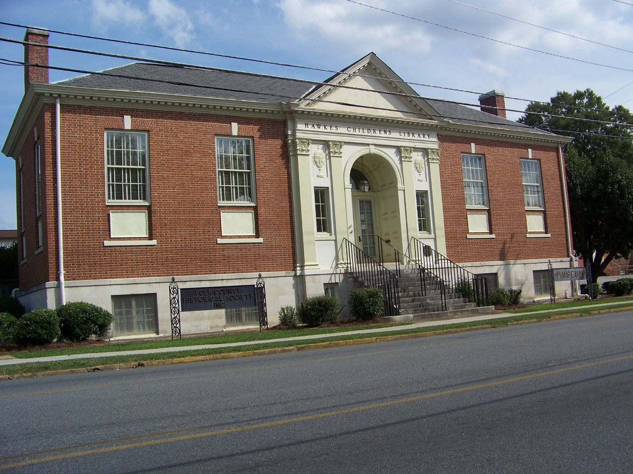 The brick former Hawkes Children's Library with Polk County Historical Society and museum signs.