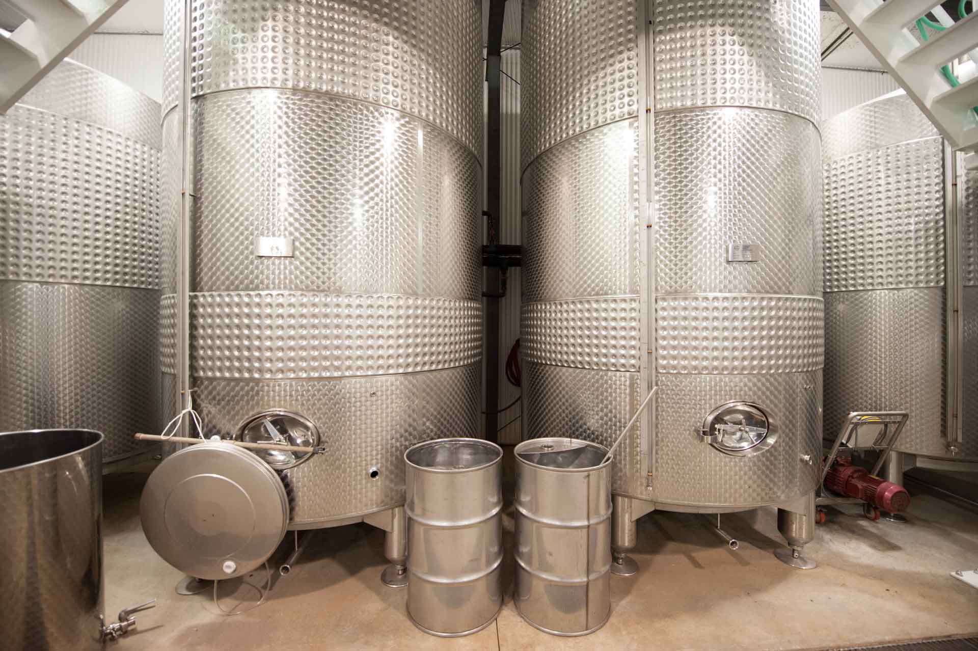 Tall stainless fermentation tanks inside Still Pond Winery's production room.