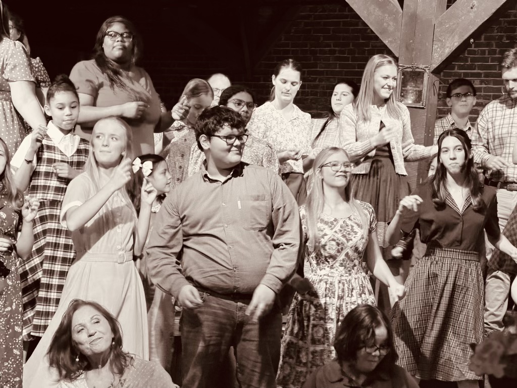 The intergenerational Swamp Gravy cast performing together on Cotton Hall's rustic stage.