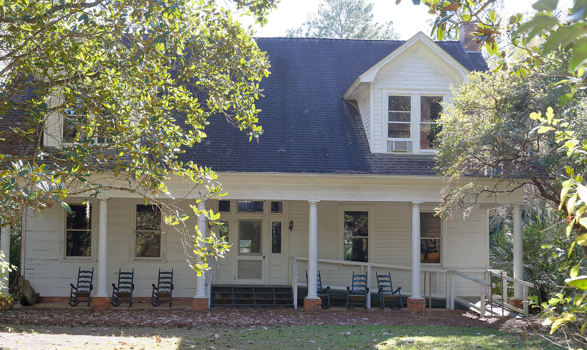 The historic Birdsong house and shaded porch on the Birdsong Nature Center grounds.