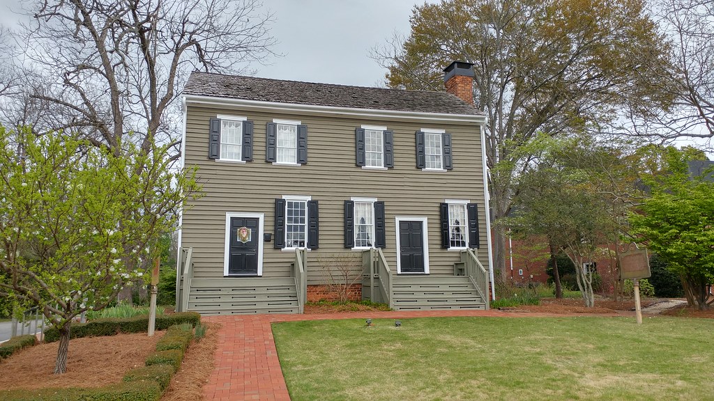The restored green wooden Eagle Tavern with twin stairs and black shutters in Watkinsville.