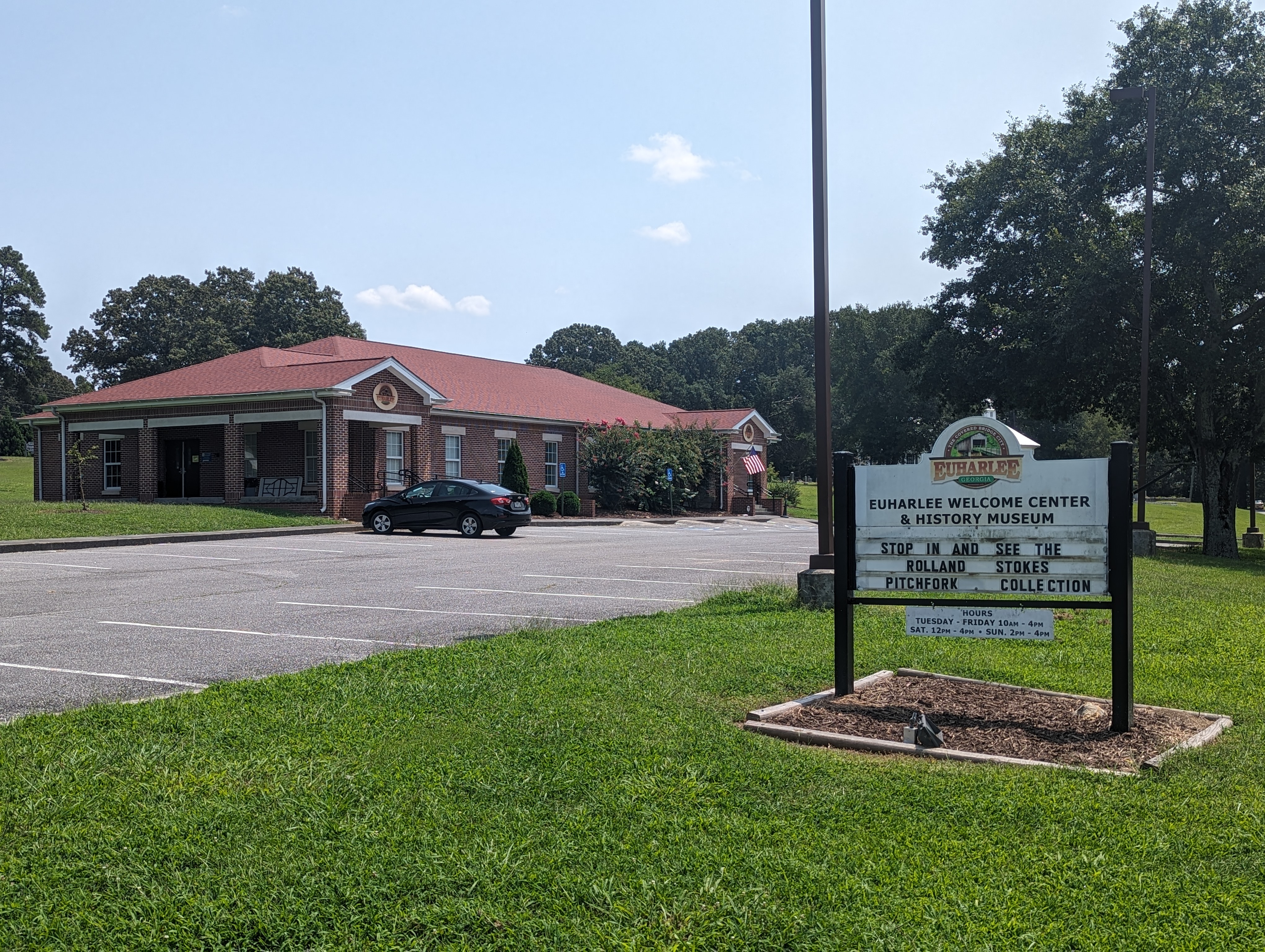 The brick Euharlee Welcome Center and History Museum with its roadside sign and accessible parking.