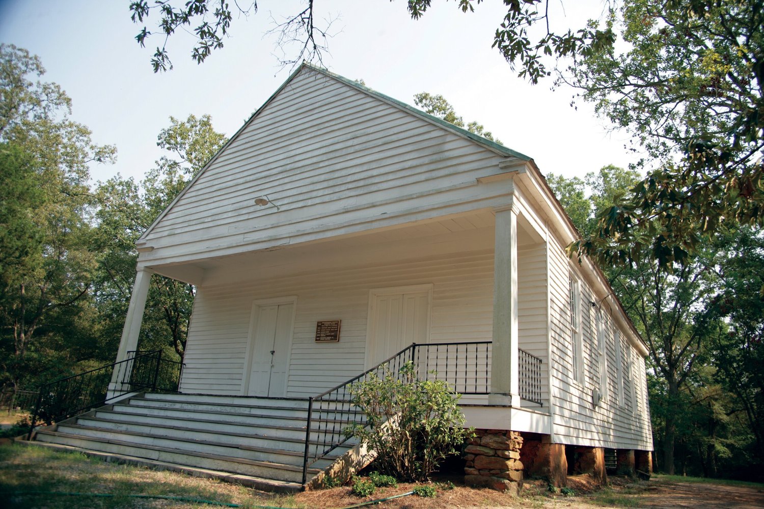 The white historic Wrightsboro church, front steps and stone foundation piers.