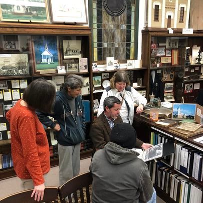 Visitors stand among local-history exhibits inside the Quitman Brooks County Museum.