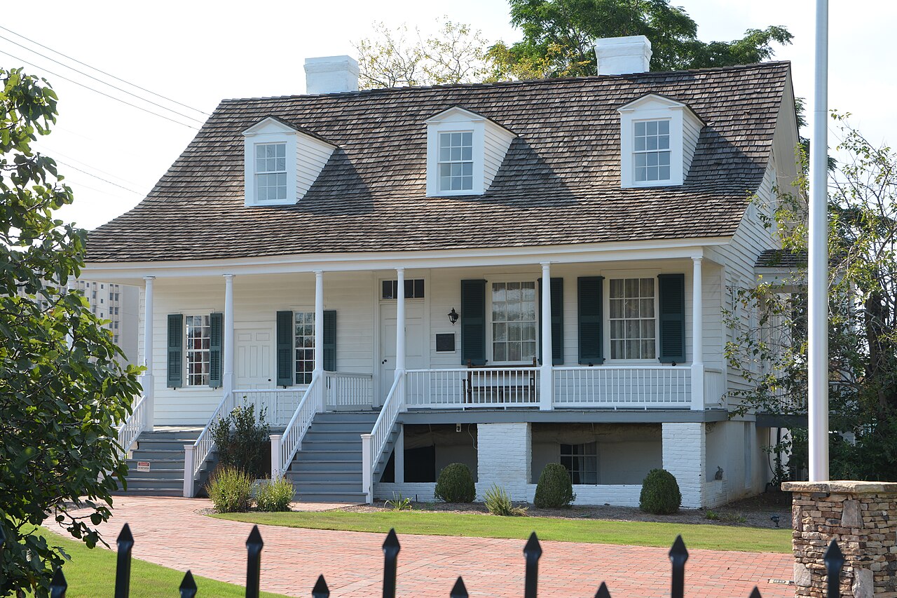 The white historic Meadow Garden house and its full-width porch in Augusta.