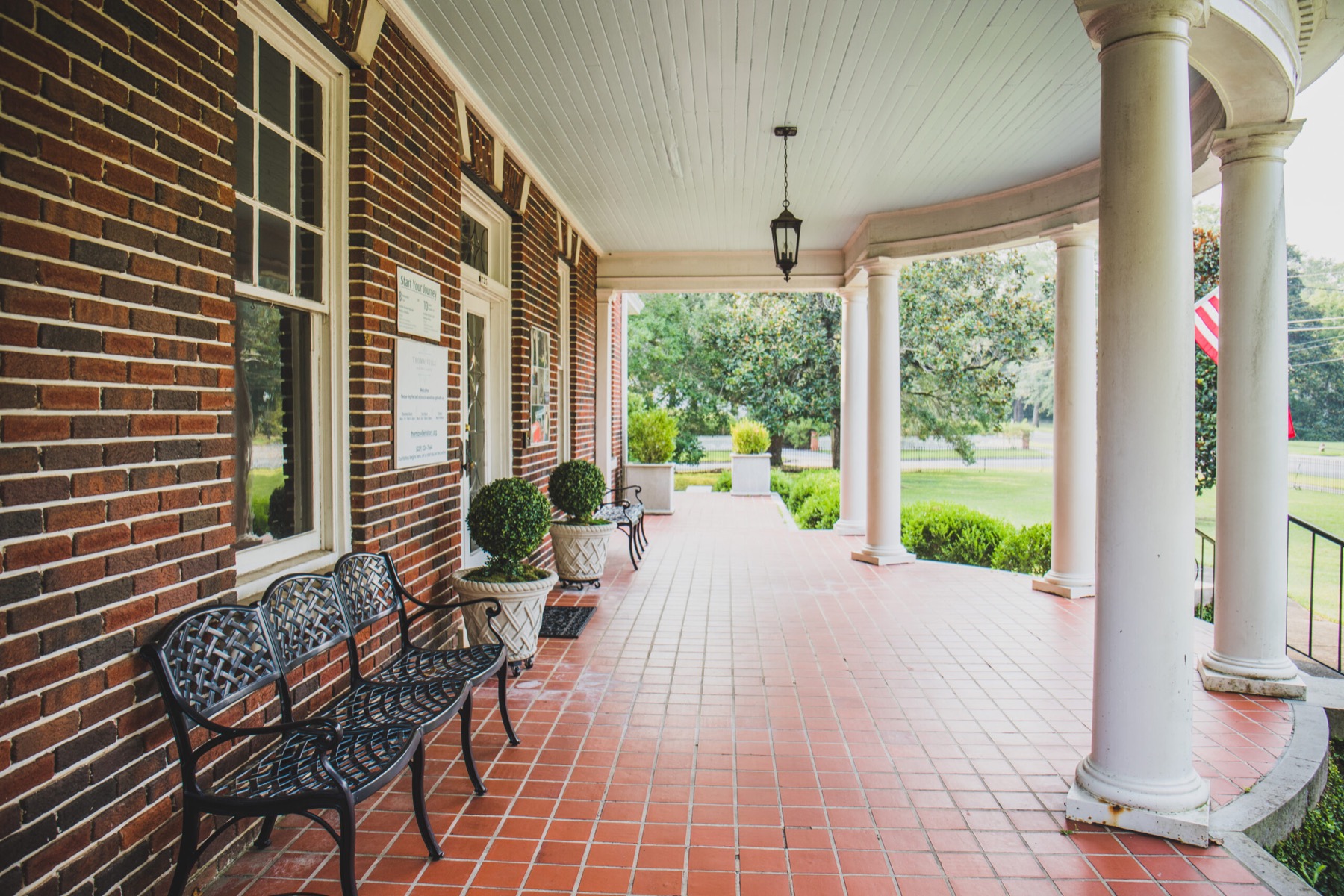 The porch and visitor entrance at the Thomasville History Center with a ticket-price sign.