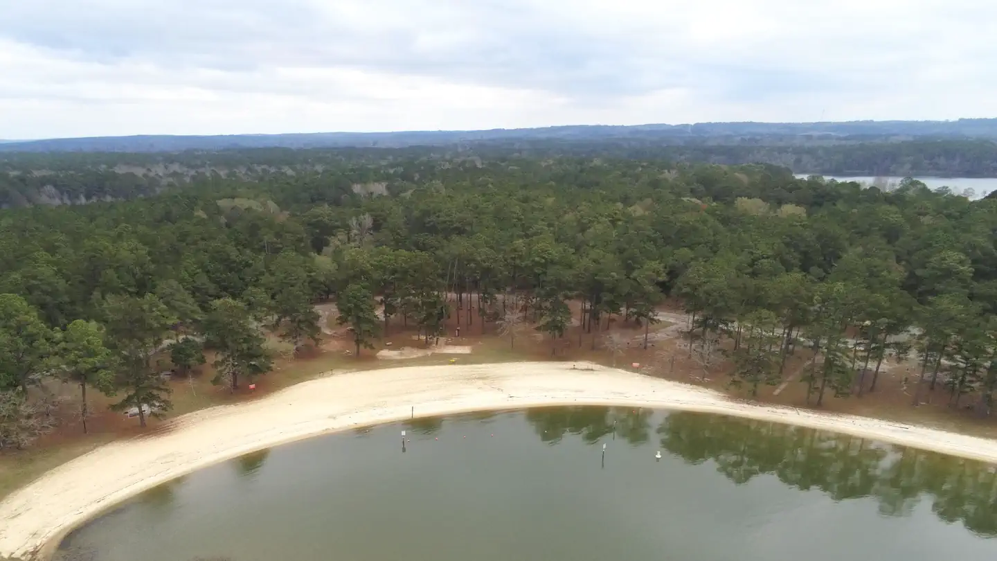 An aerial view of Cotton Hill Campground's pine-shaded campsites, swim beach and Lake Walter F. George shoreline.