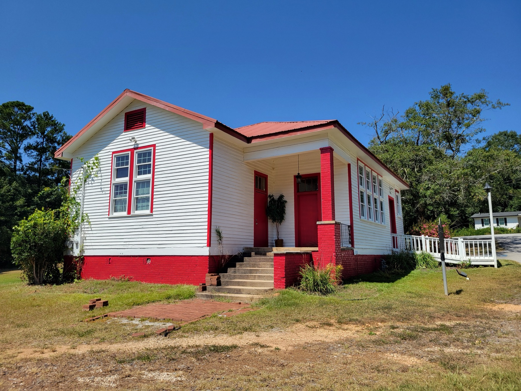 The restored white-and-red Hiram Rosenwald School building with its entrance and mobility ramp.