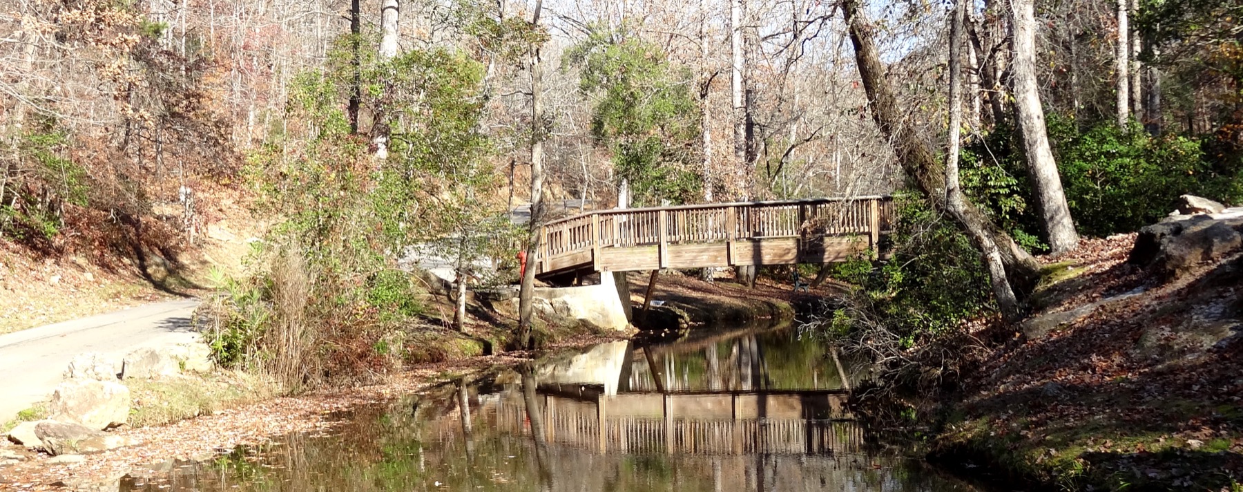 A 2014 view of Rice Creek and a wooden bridge at Victoria Bryant State Park; current bridge status must be checked separately.