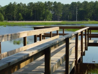 Wooden fishing dock extending over the water at Whitewater Creek Park